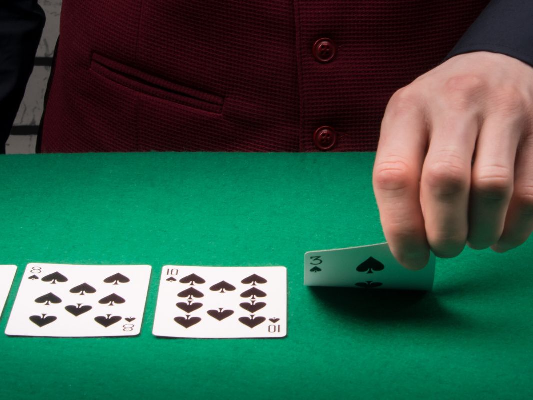 Hombre volteando cartas en mesa de juegos